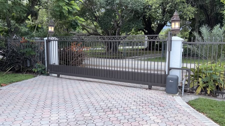 Sliding driveway gate with its operator